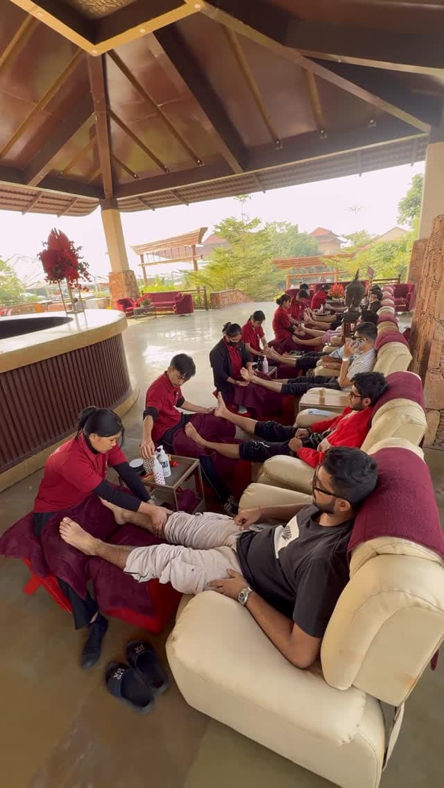 Therapists giving foot massages side by side under the garden pavilion