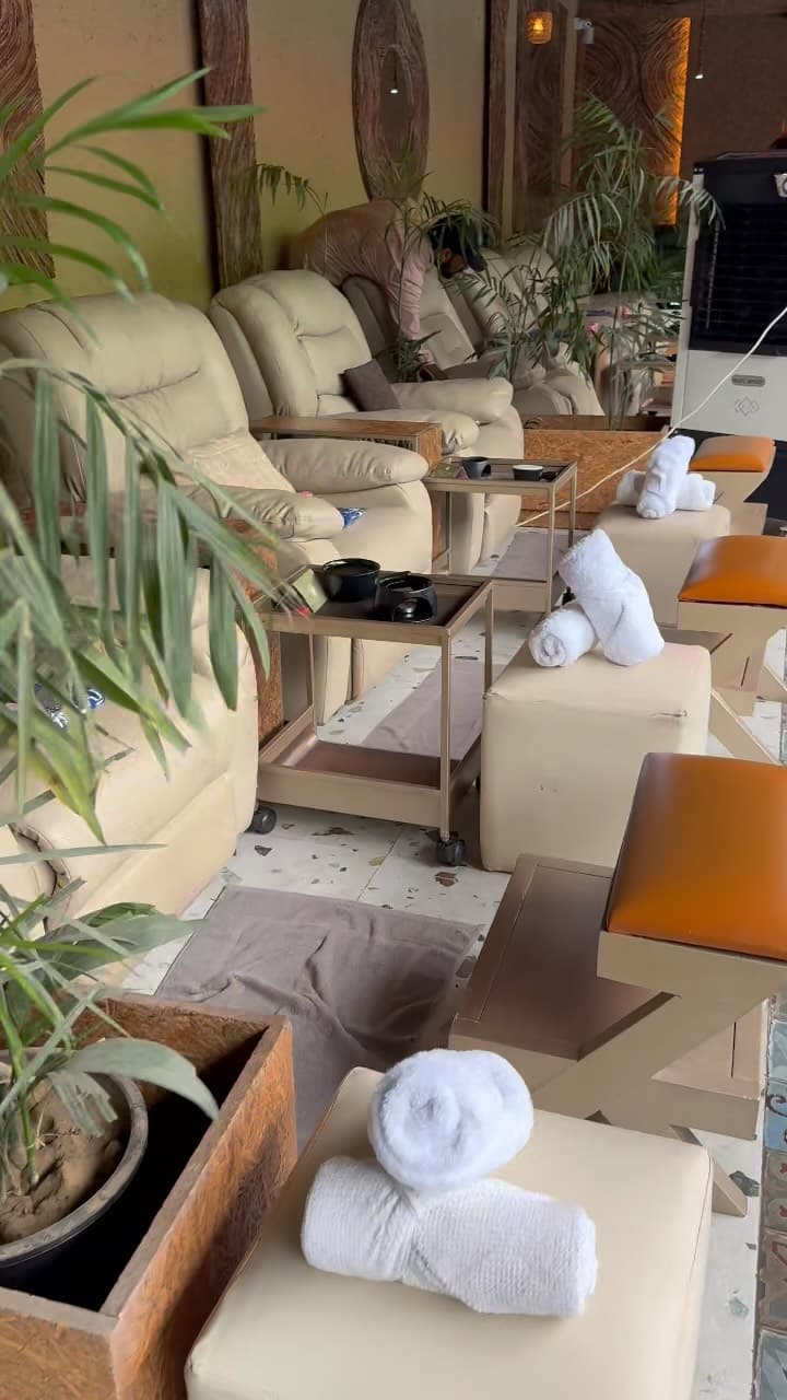 Rows of cream recliners, rolled towels and plants in the studio